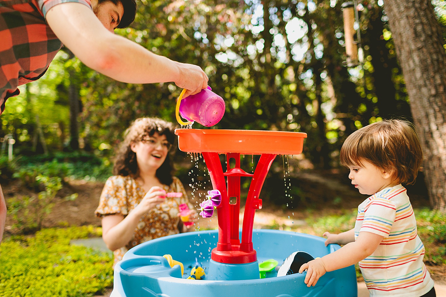 Parents playing at water table with toddler