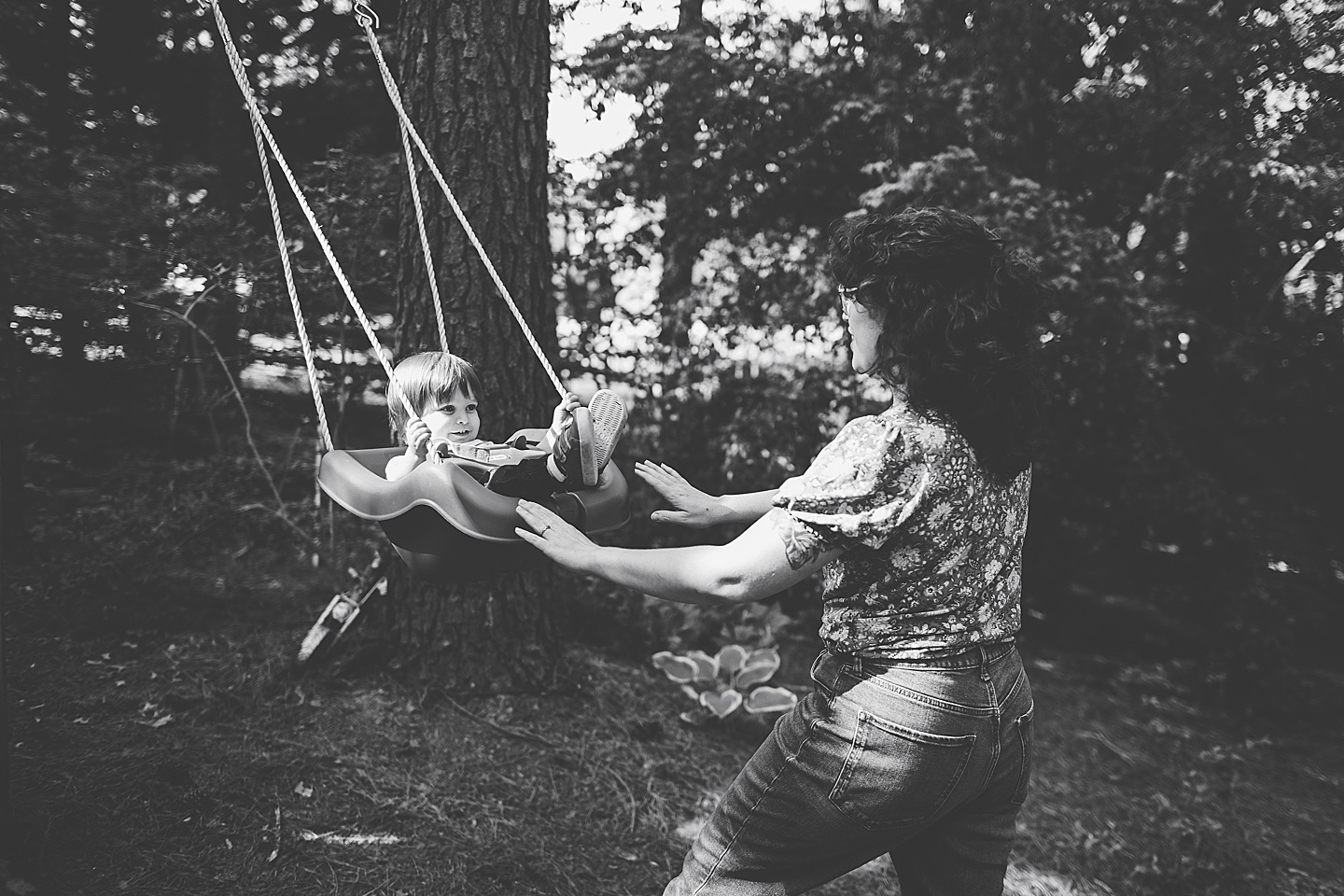 Mom pushing toddler on a swing