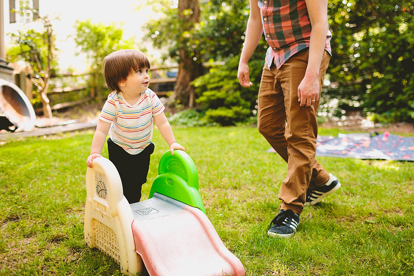 Toddler using tiny slide in yard