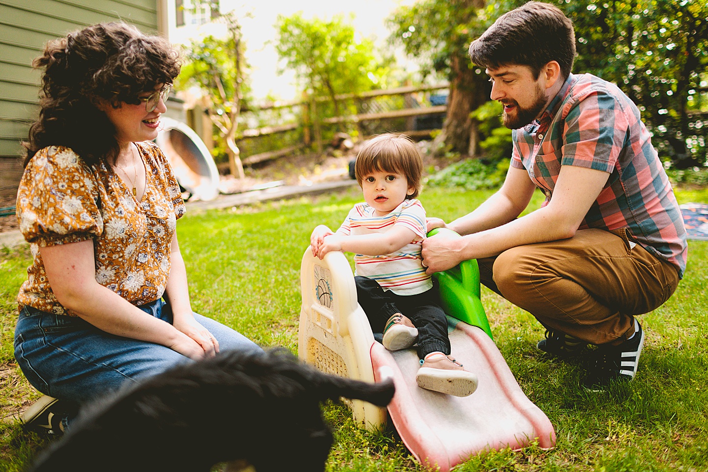 Toddler using tiny slide in yard