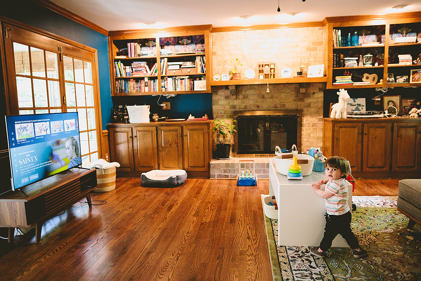 Toddler standing in living room holding remote control