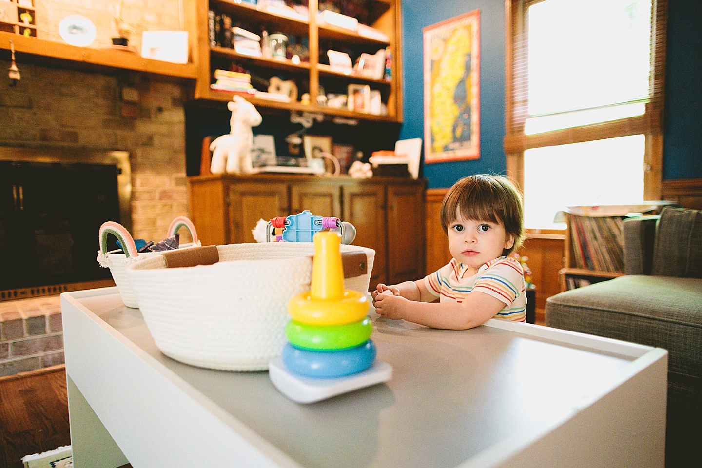 Toddler standing in living room holding remote control