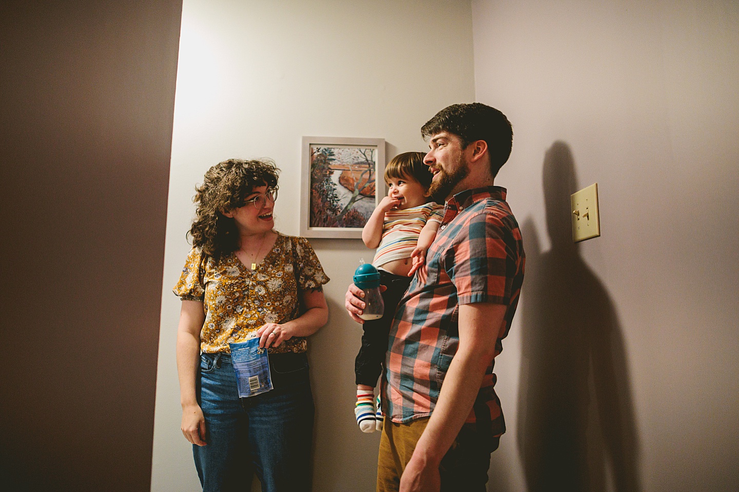 Family carrying toddler up the stairs