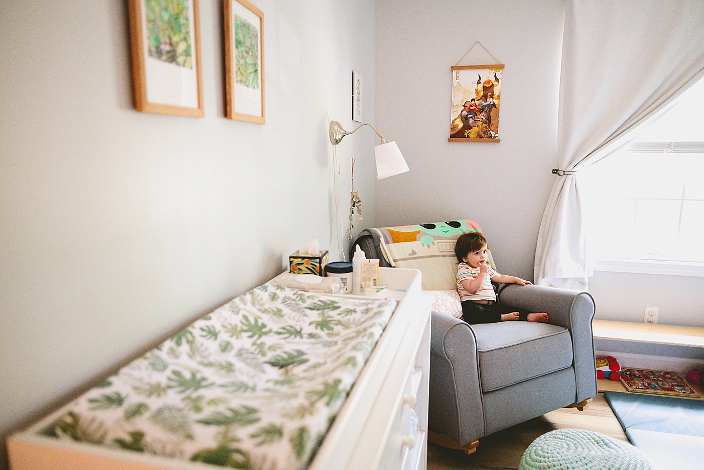 Toddler sitting in big chair in his room