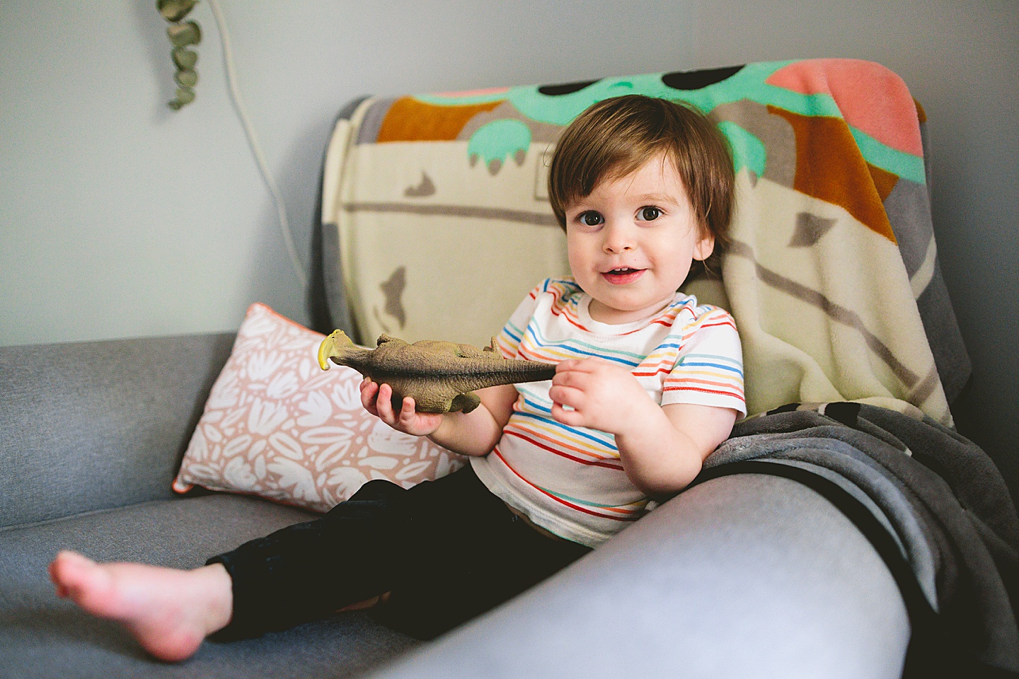 Toddler sitting in big chair in his room