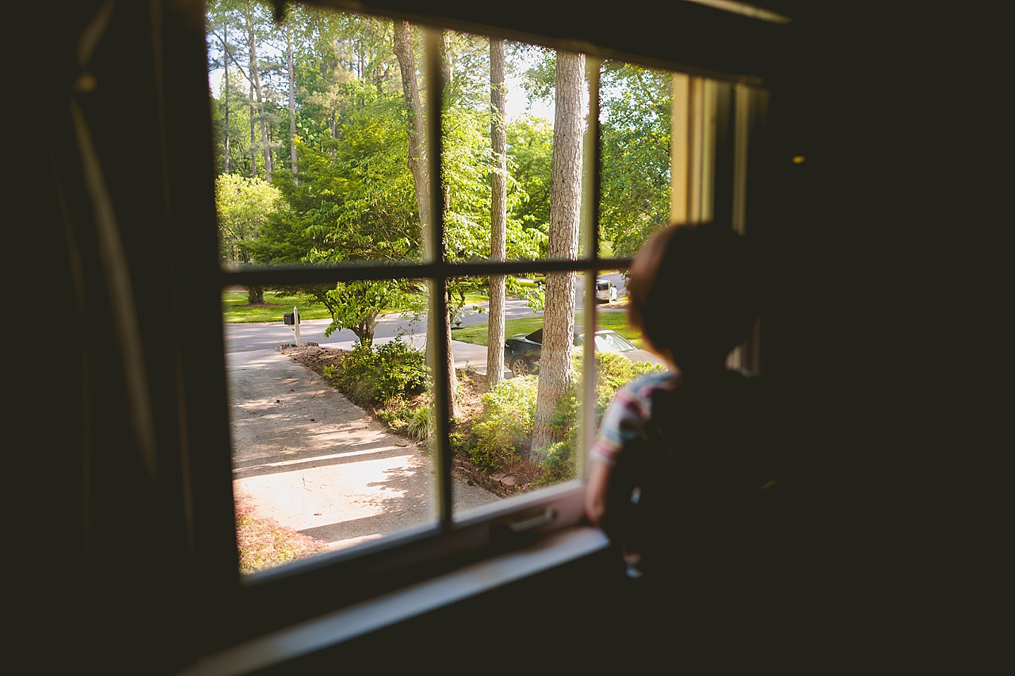 Little kid looks out window