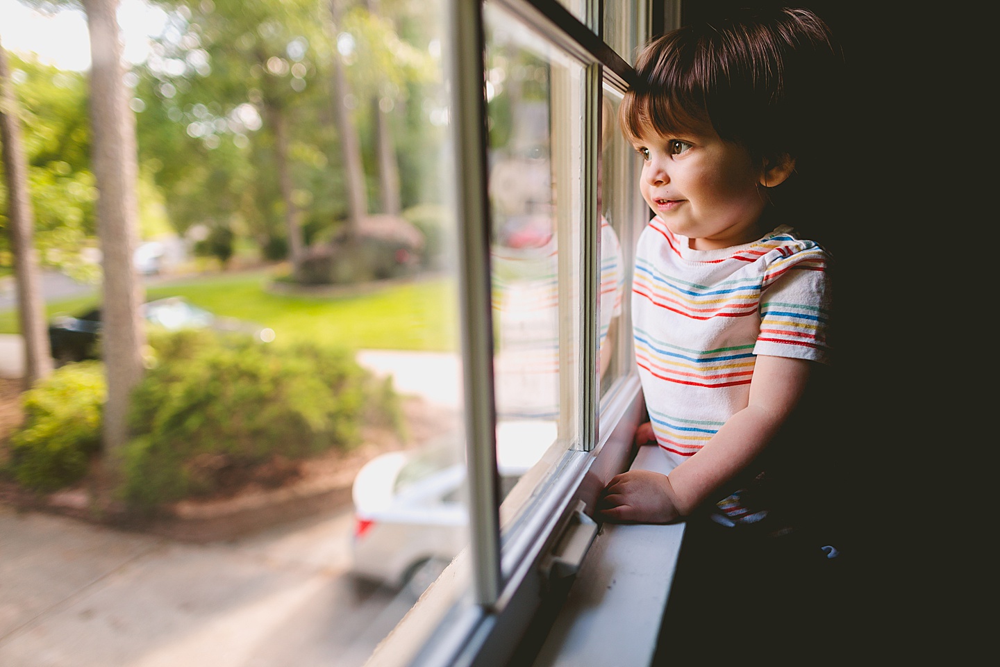 Little kid looks out window