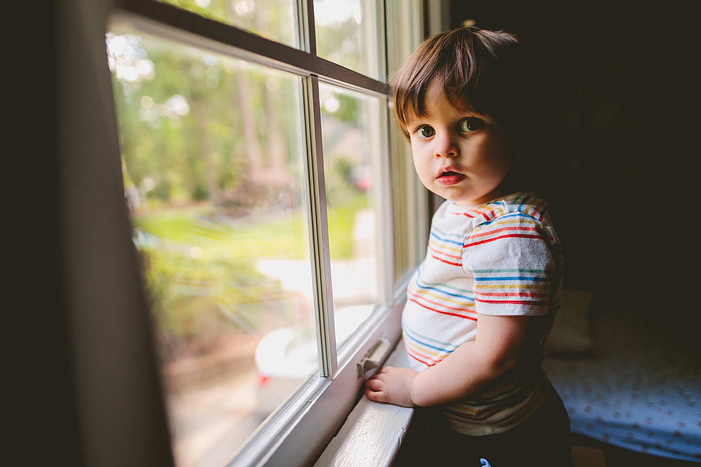 Little kid looks out window