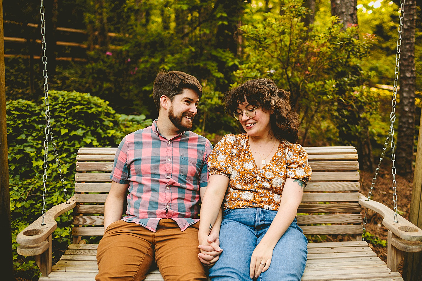 Couple sitting on backyard swing and laughing