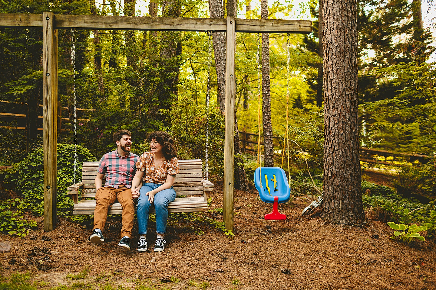 Couple sitting on backyard swing and laughing