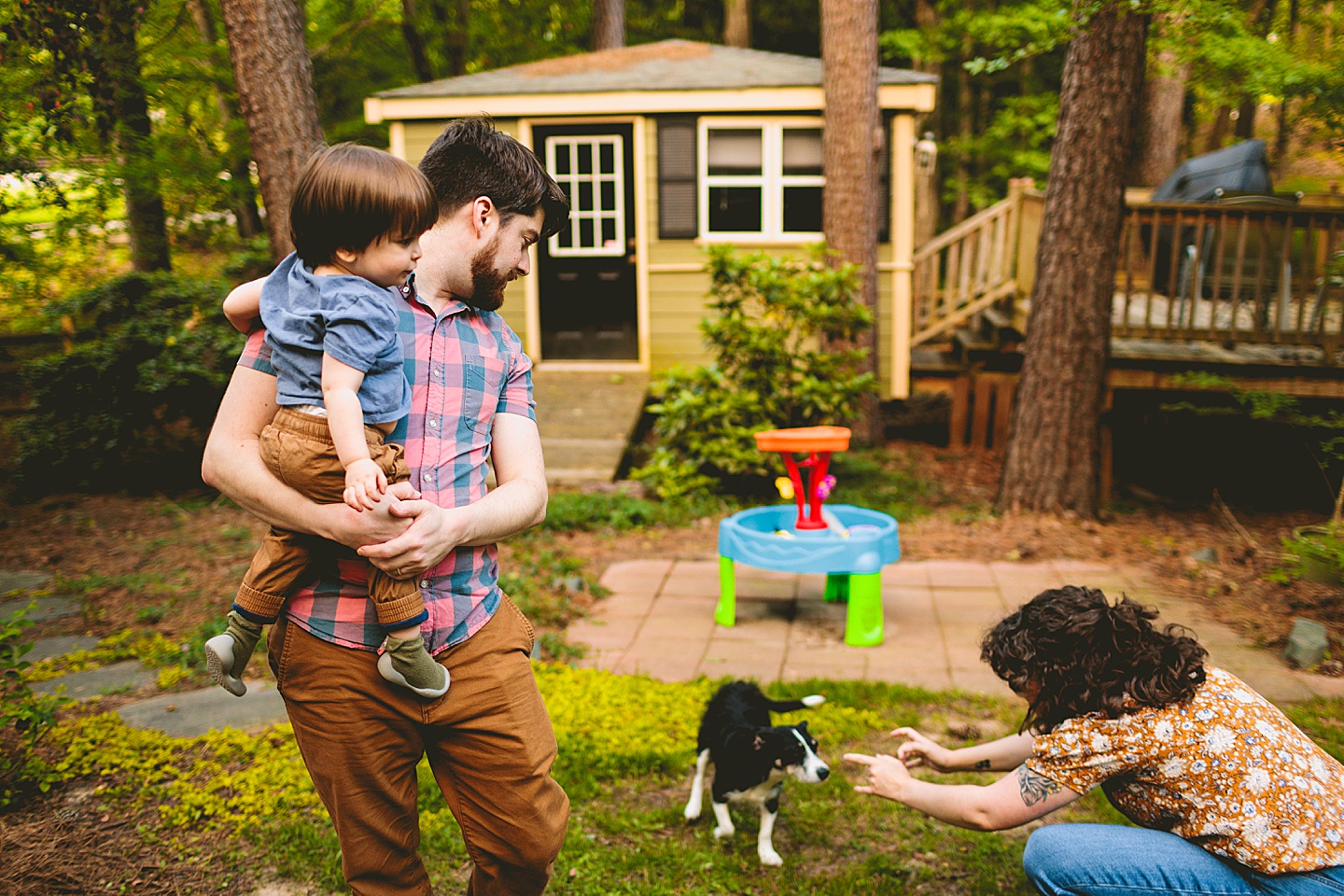 Parents playing with dog and kid in yard