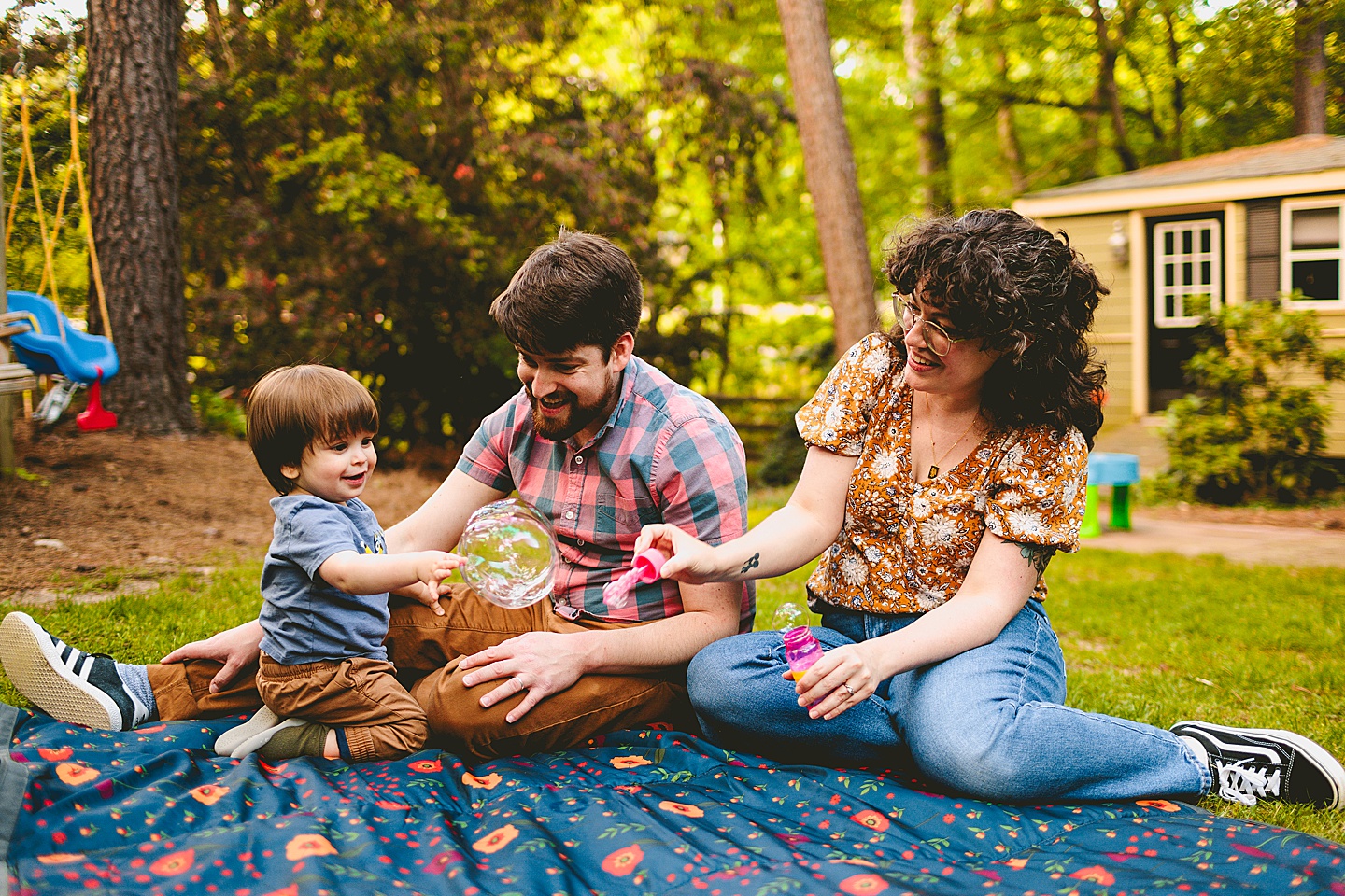 Parents playing with bubbles and kid