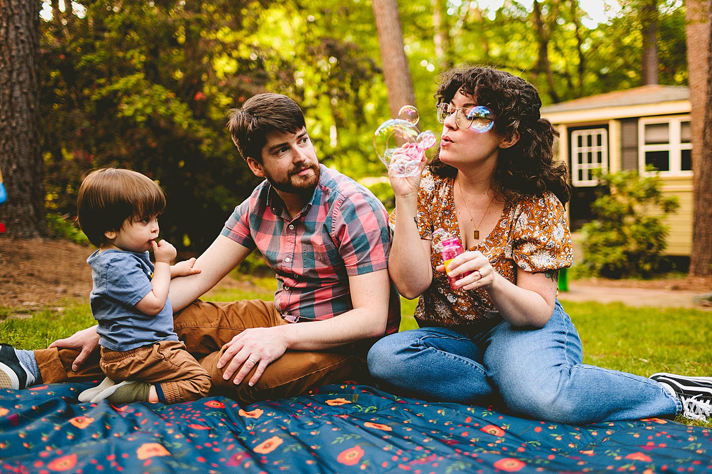 Parents playing with bubbles and kid