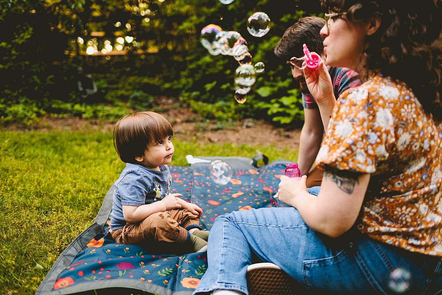Parents playing with bubbles and kid
