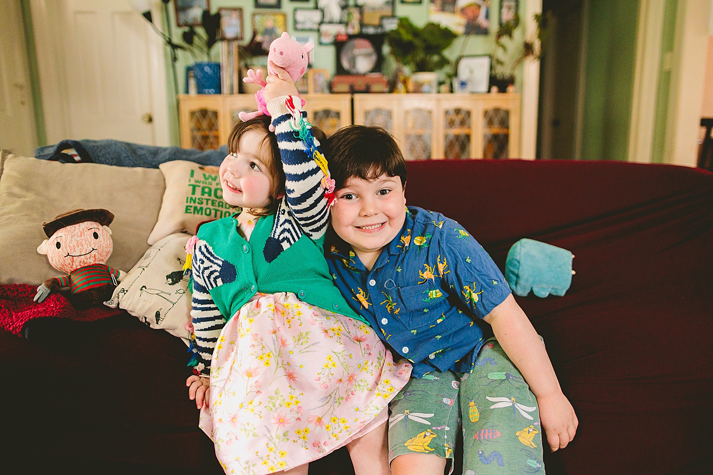 Siblings during at home family portraits in durham sit on couch