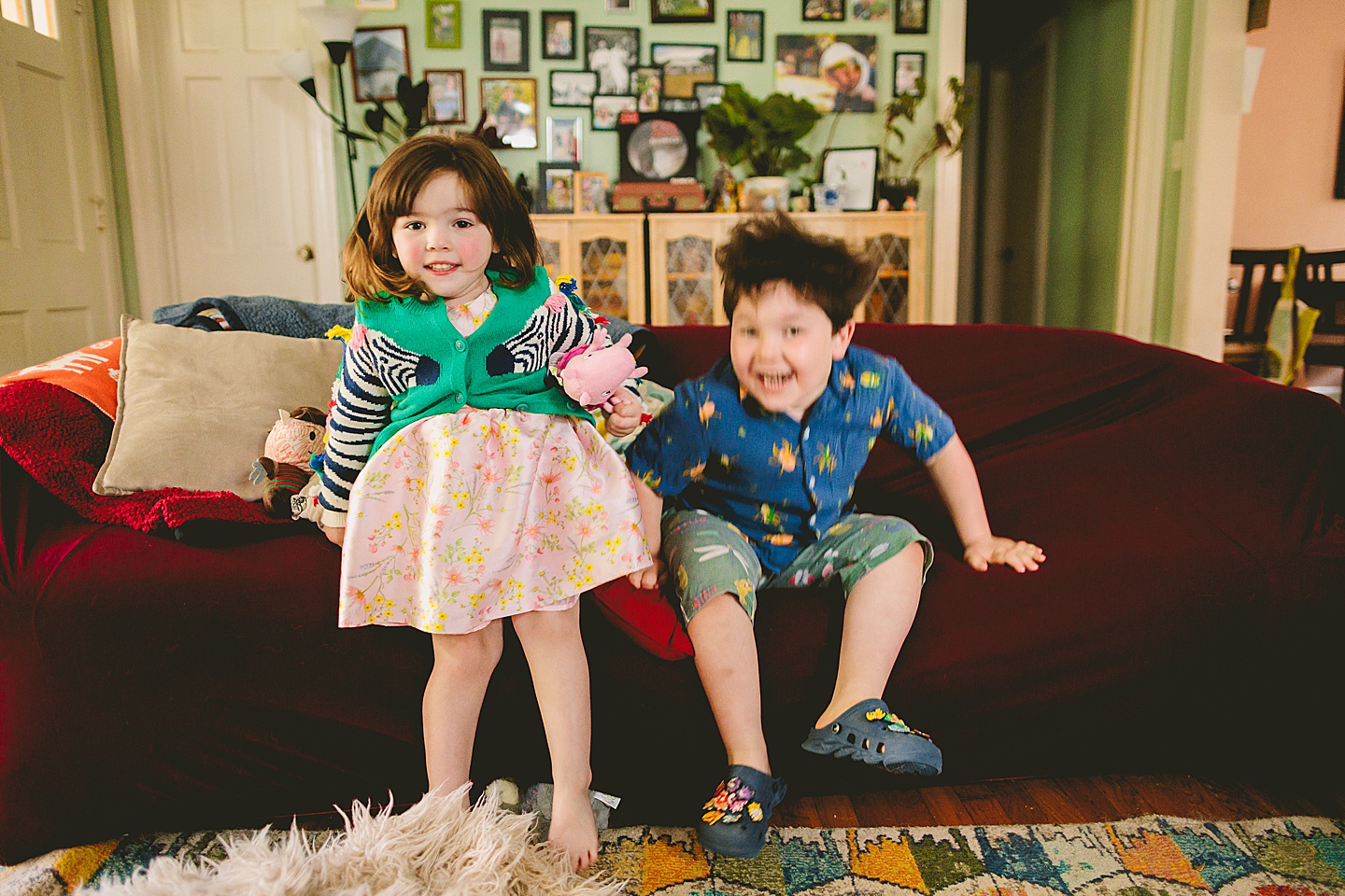 Siblings during at home family portraits in durham sit on couch