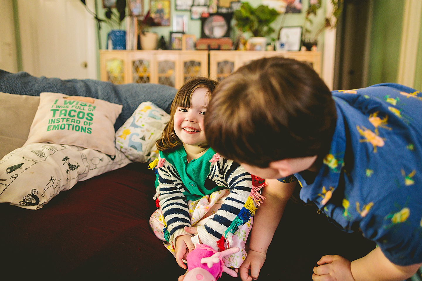 Siblings during at home family portraits in durham sit on couch