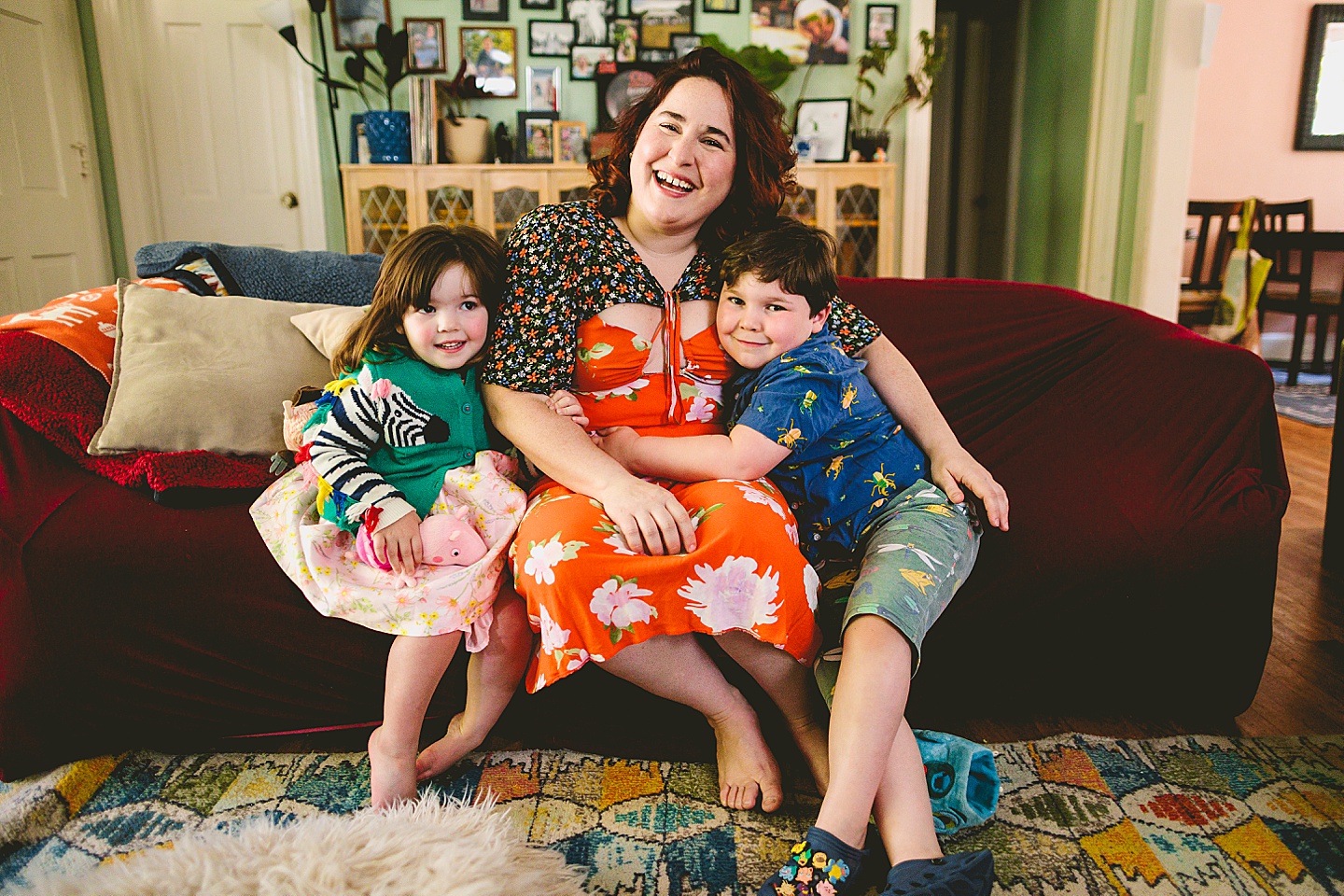 Siblings during at home family portraits in durham sit on couch