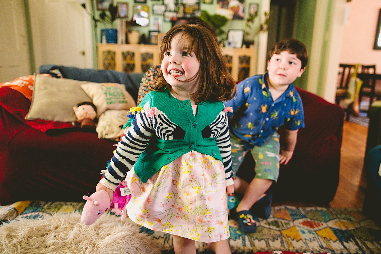 Siblings during at home family portraits in durham sit on couch