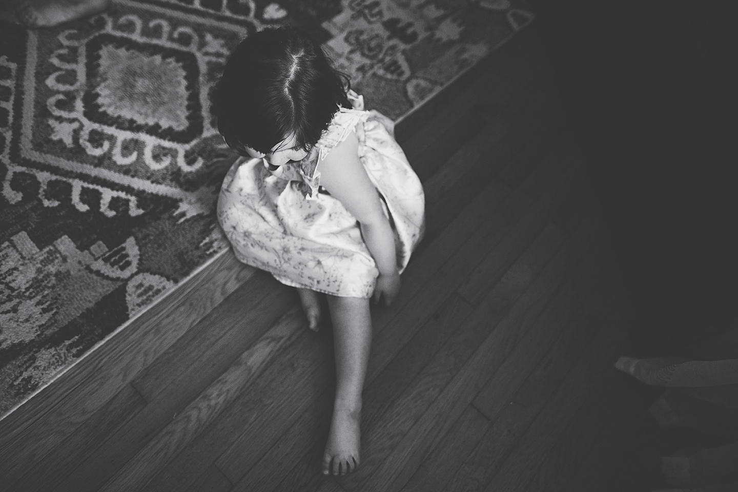Girl sitting on the floor in a dress black and white image