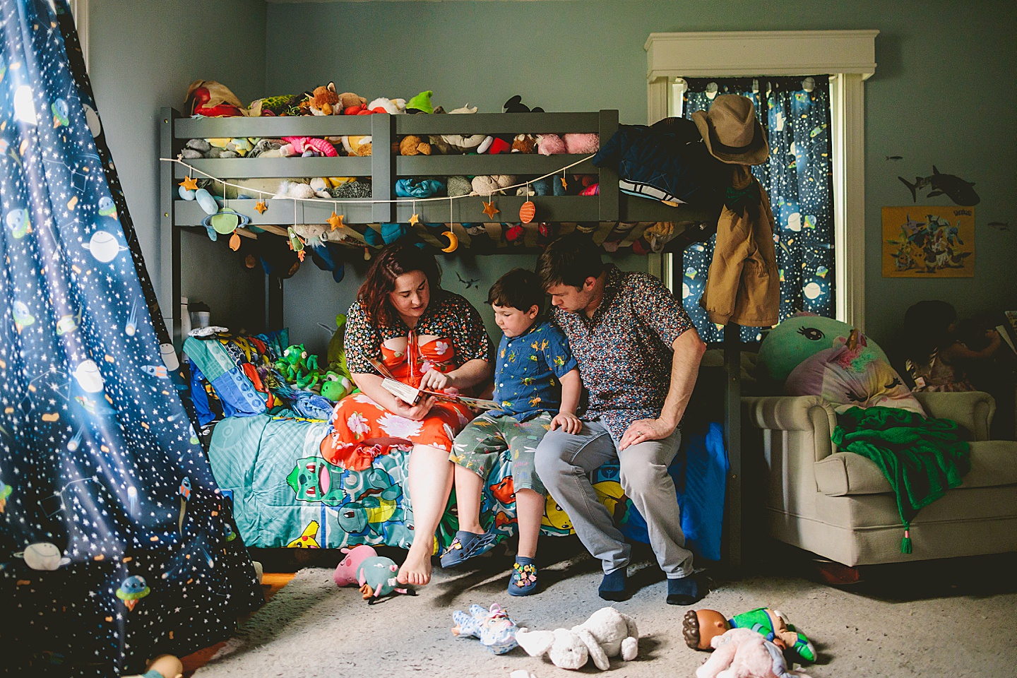 Family reading a book together in kid's room