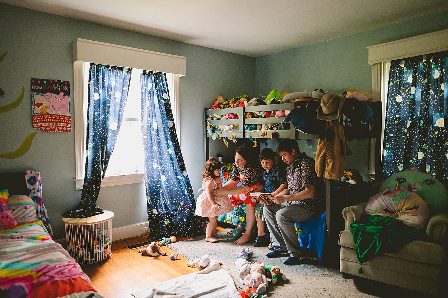 Family reading a book together in kid's room