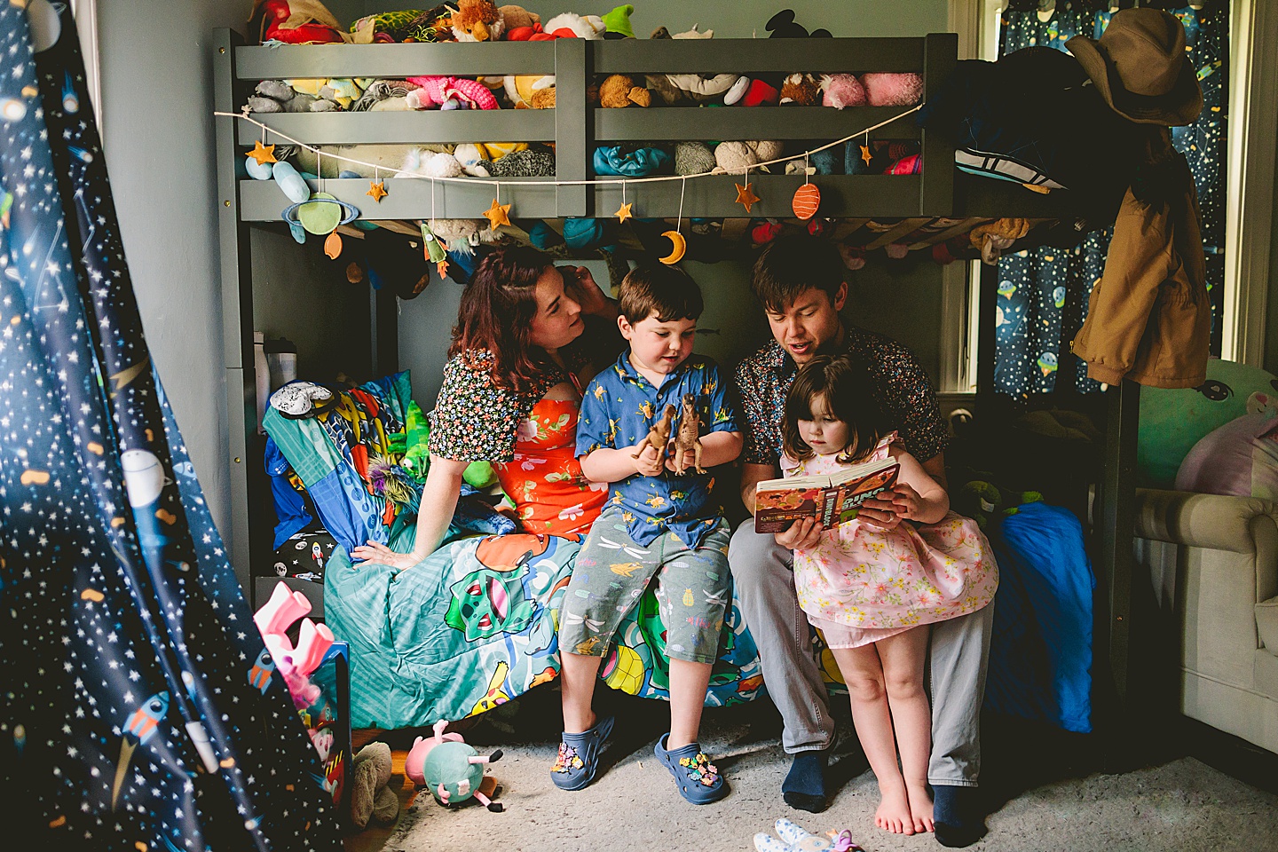 Family reading a book together in kid's room