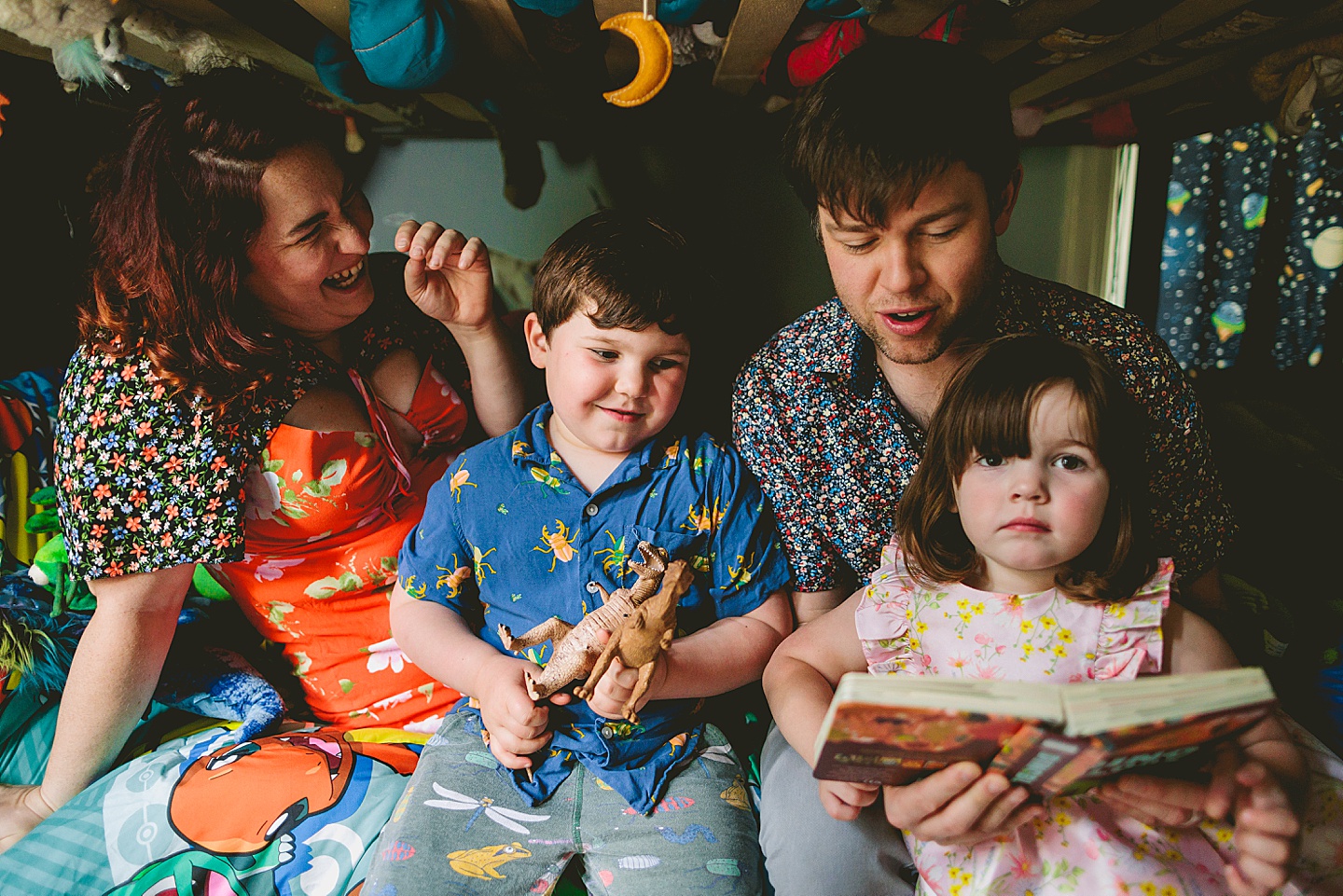 Family reading a book together in kid's room