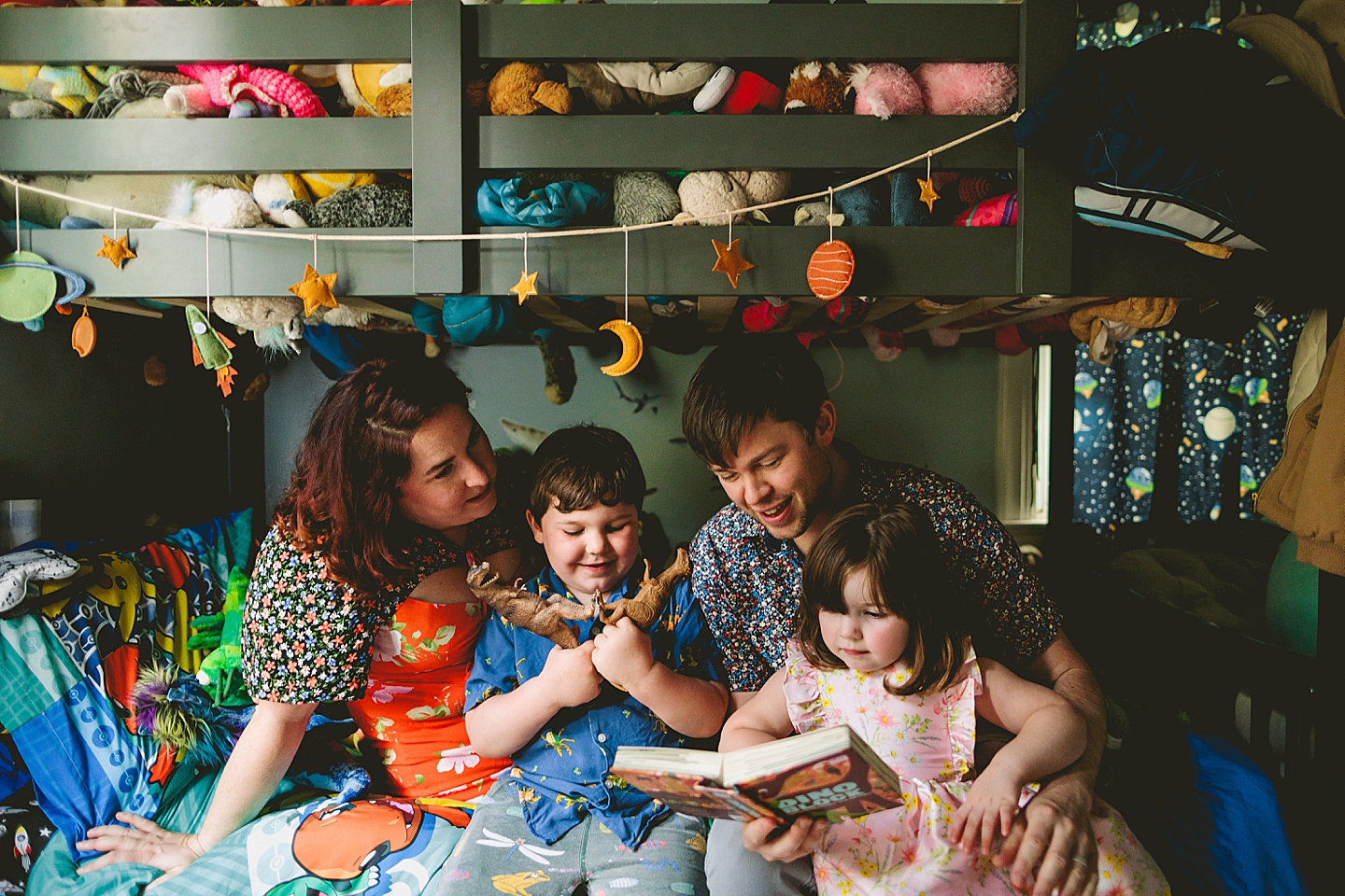 Family reading a book together in kid's room