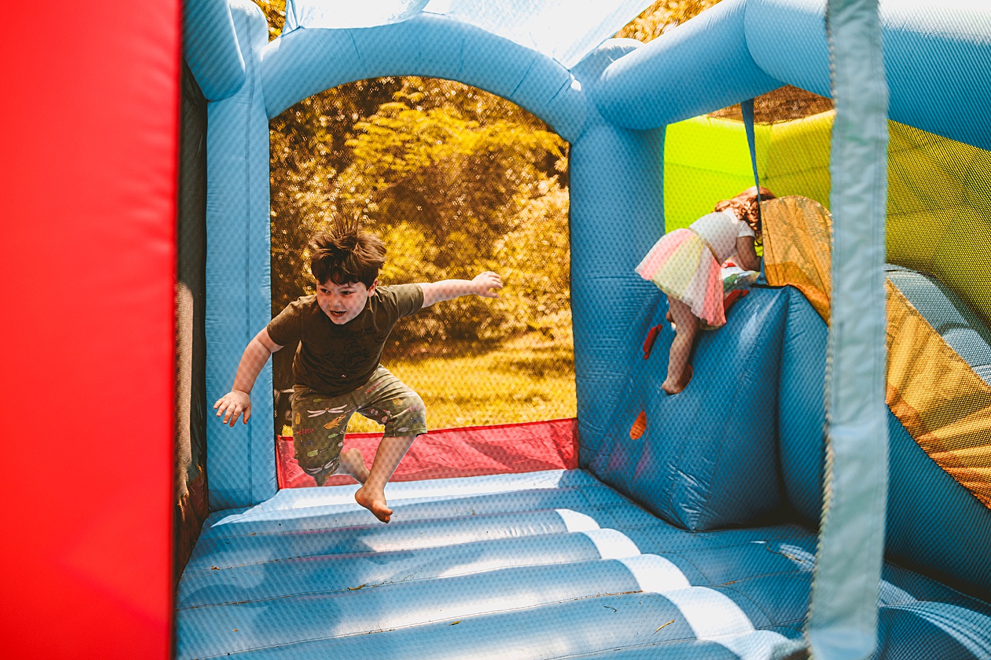 Family playing in bounce house during family photos in Durham