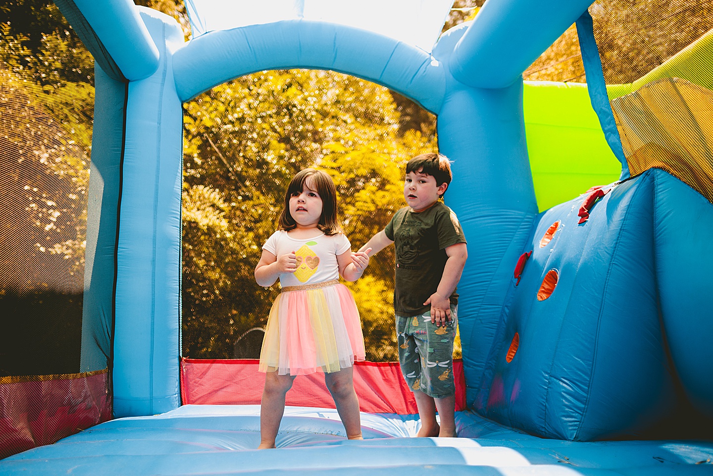 Family playing in bounce house during family photos in Durham