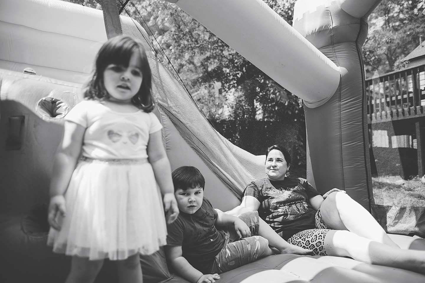 Family playing in bounce house during family photos in Durham