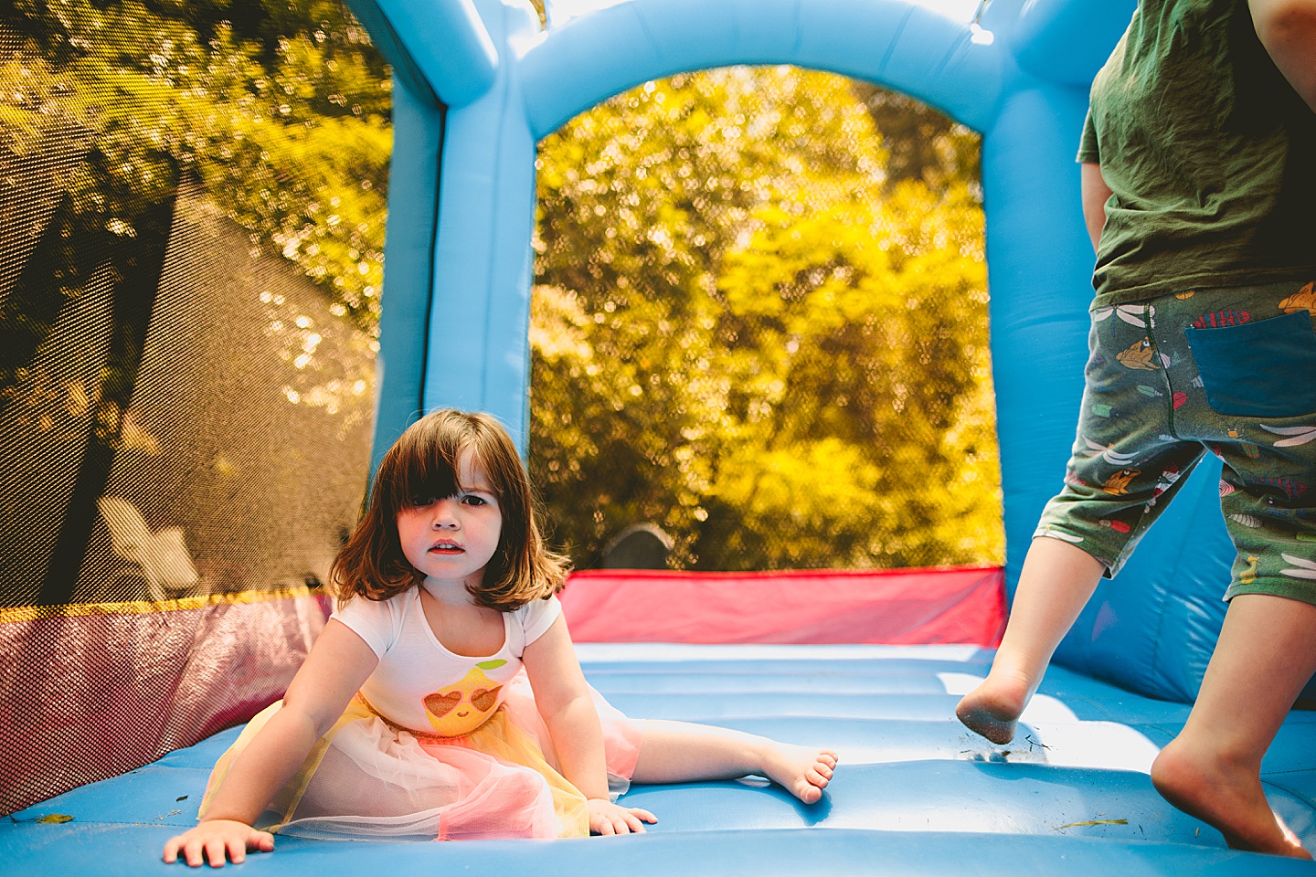 Family playing in bounce house during family photos in Durham