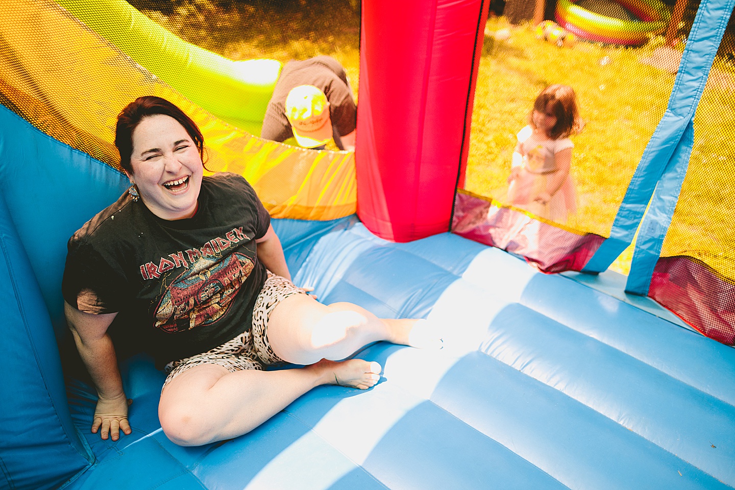 Family playing in bounce house during family photos in Durham