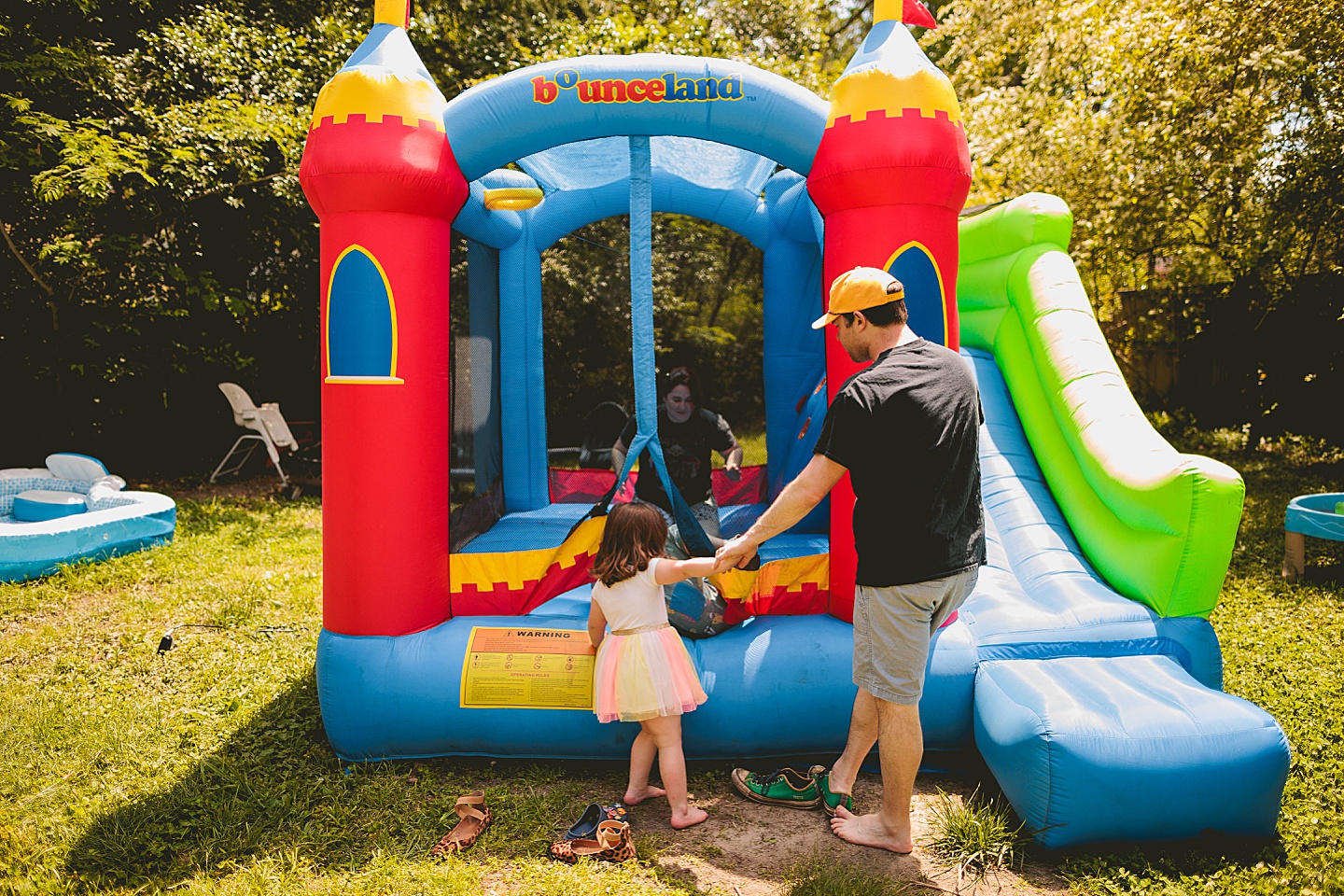 Family playing in bounce house during family photos in Durham