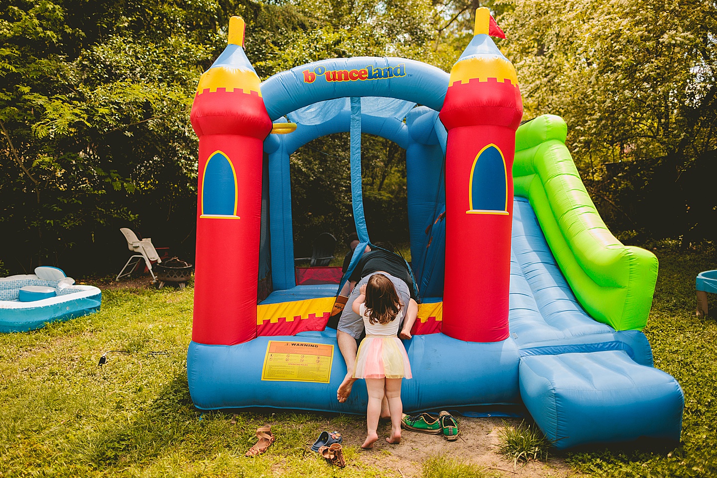 Family playing in bounce house during family photos in Durham