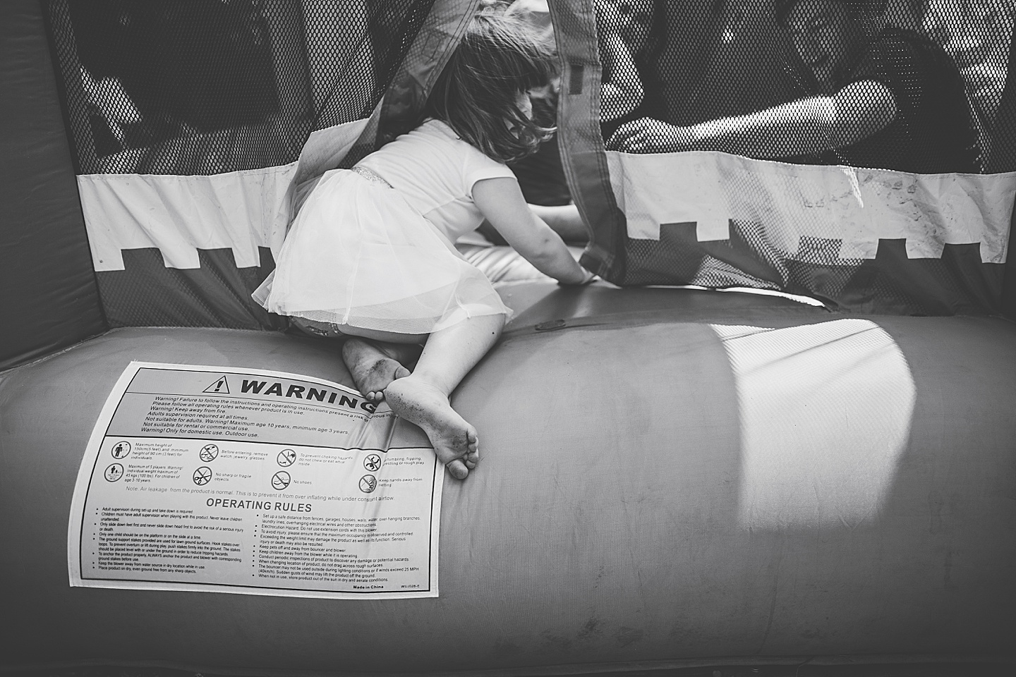 Family playing in bounce house during family photos in Durham