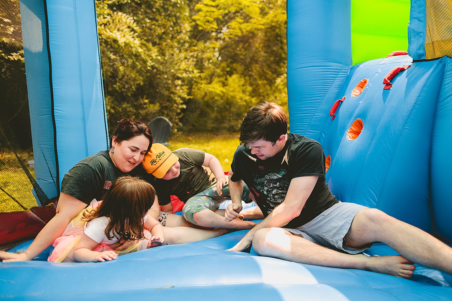 Family playing in bounce house during family photos in Durham