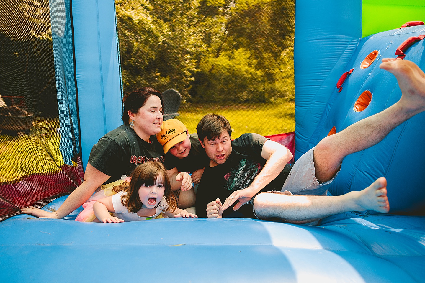 Family playing in bounce house during family photos in Durham