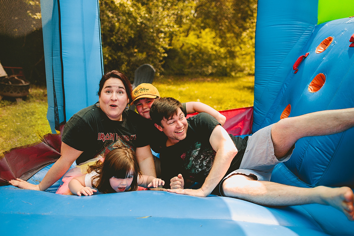 Family playing in bounce house during family photos in Durham