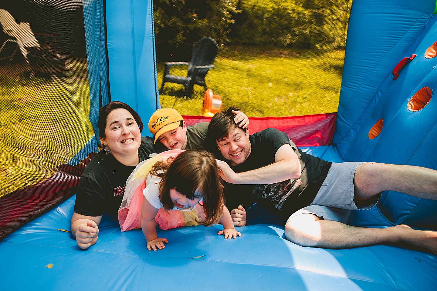 Family playing in bounce house during family photos in Durham