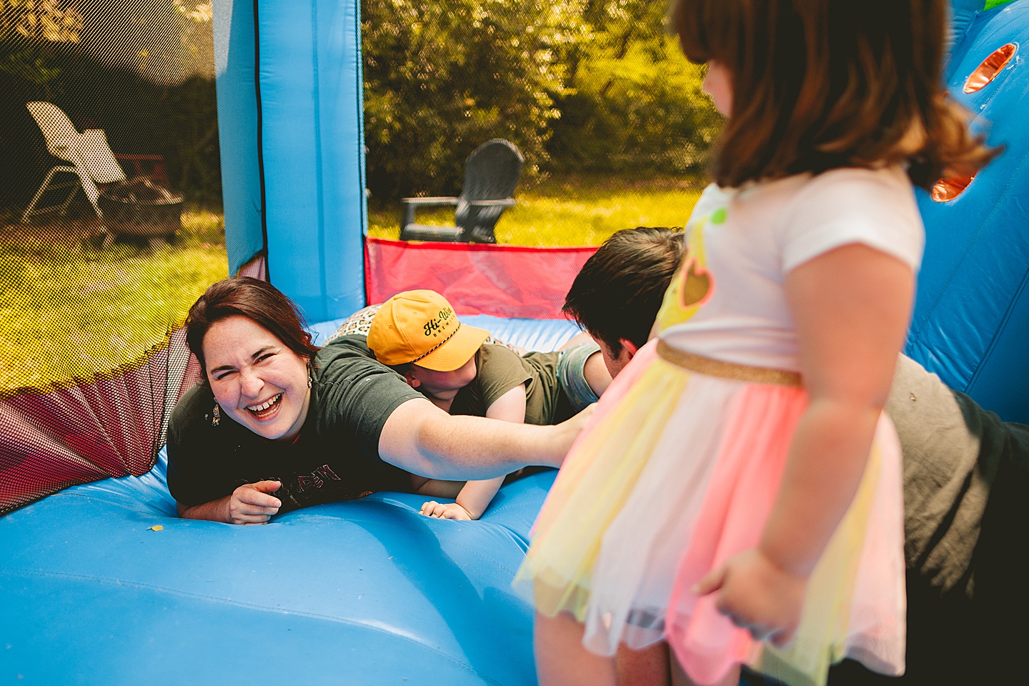 Family playing in bounce house during family photos in Durham