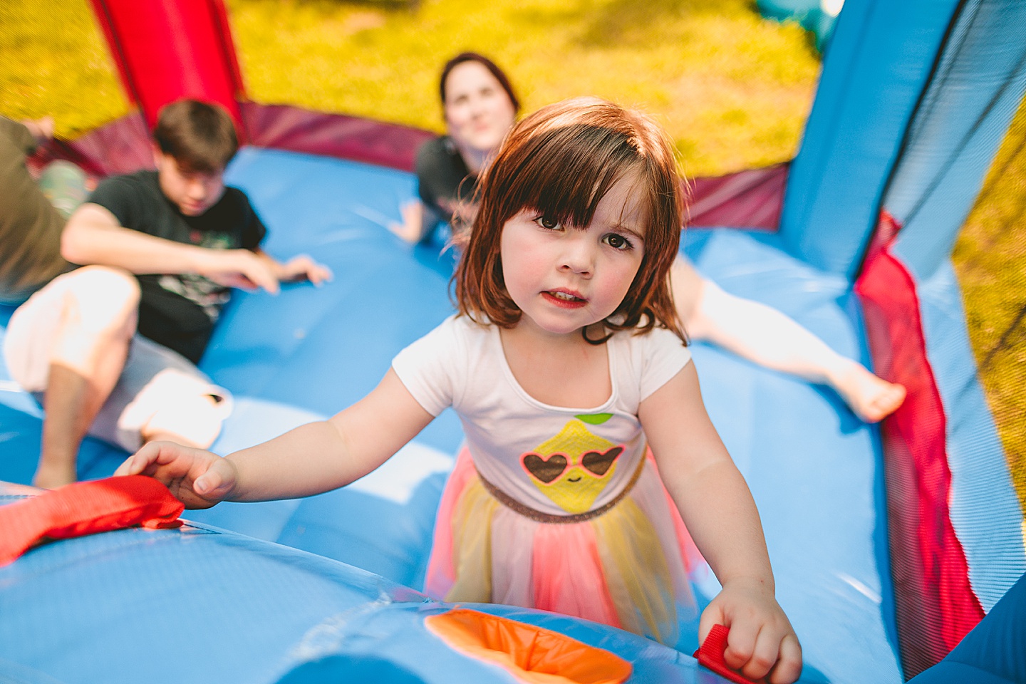 Family playing in bounce house during family photos in Durham