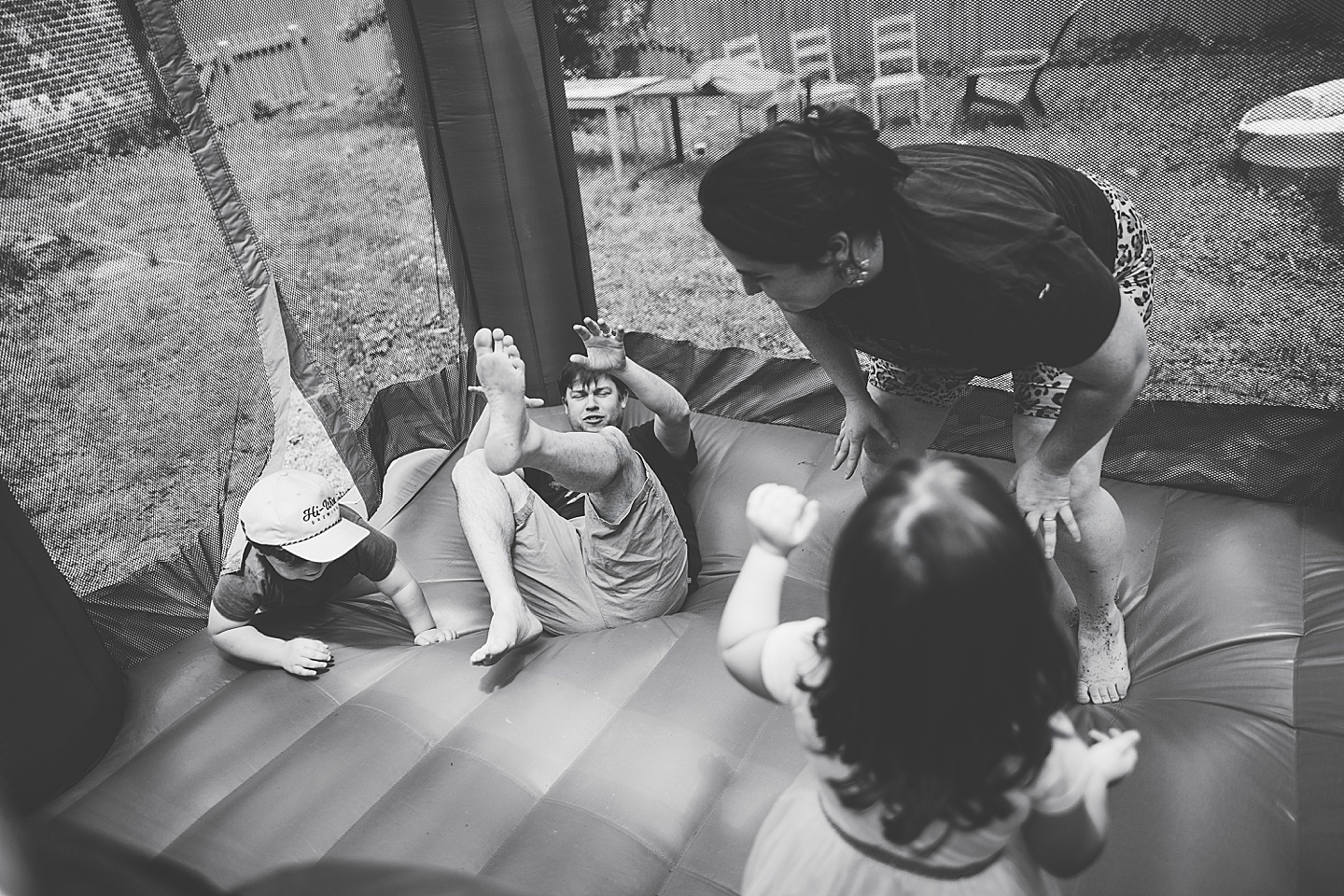 Family playing in bounce house during family photos in Durham