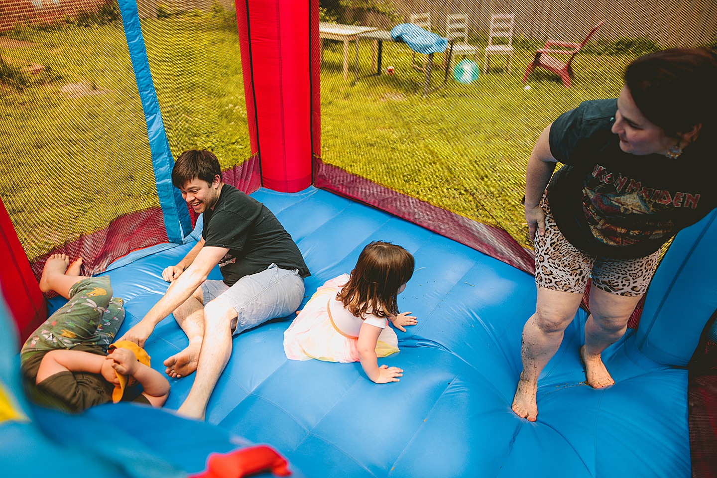 Family playing in bounce house during family photos in Durham