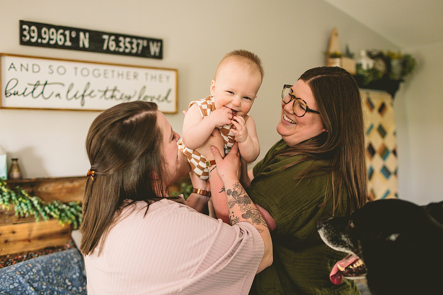 Parents holding laughing baby on bed