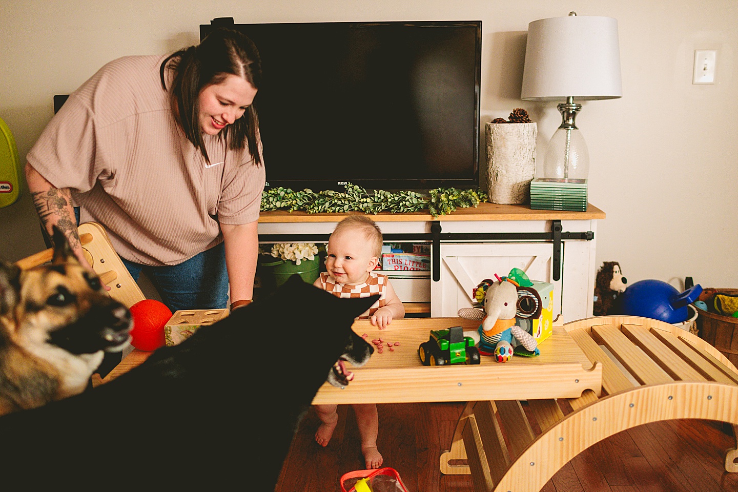 Baby eating a snack with dog friends