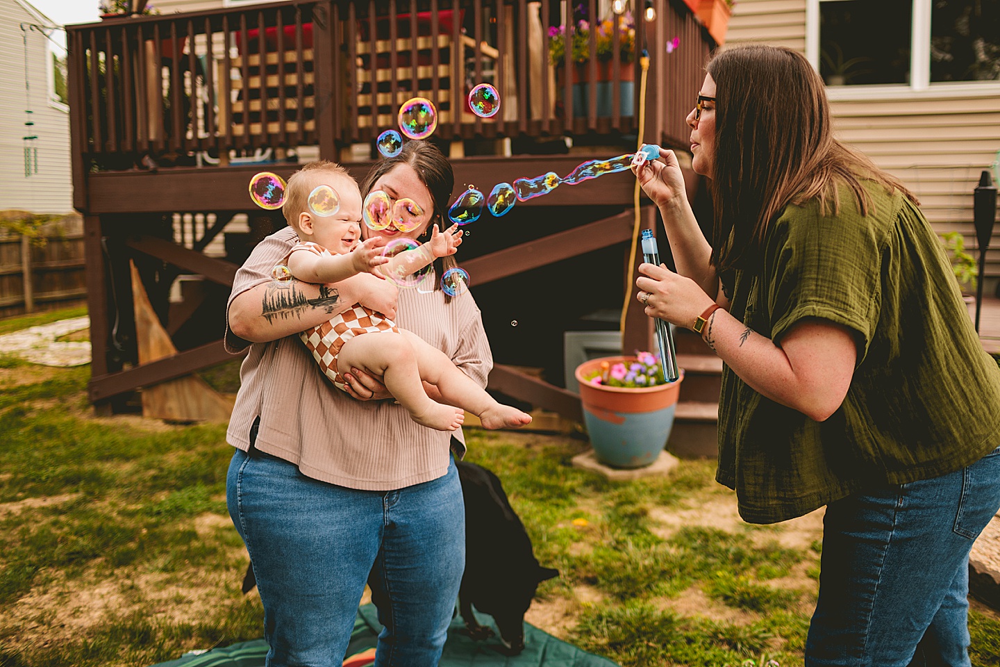 Women blowing bubbles for baby