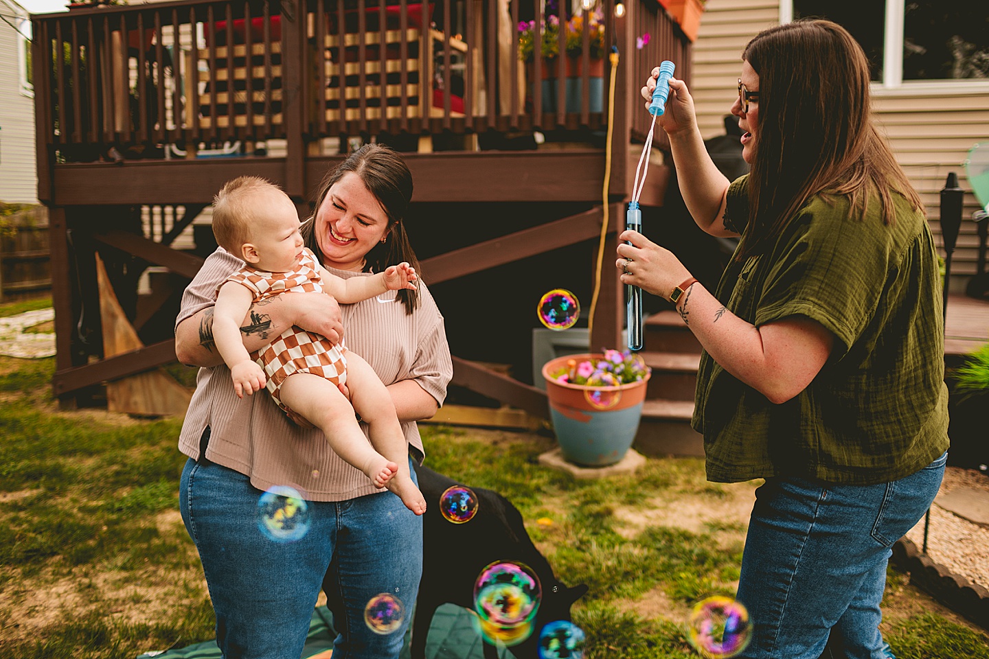 Women blowing bubbles for baby