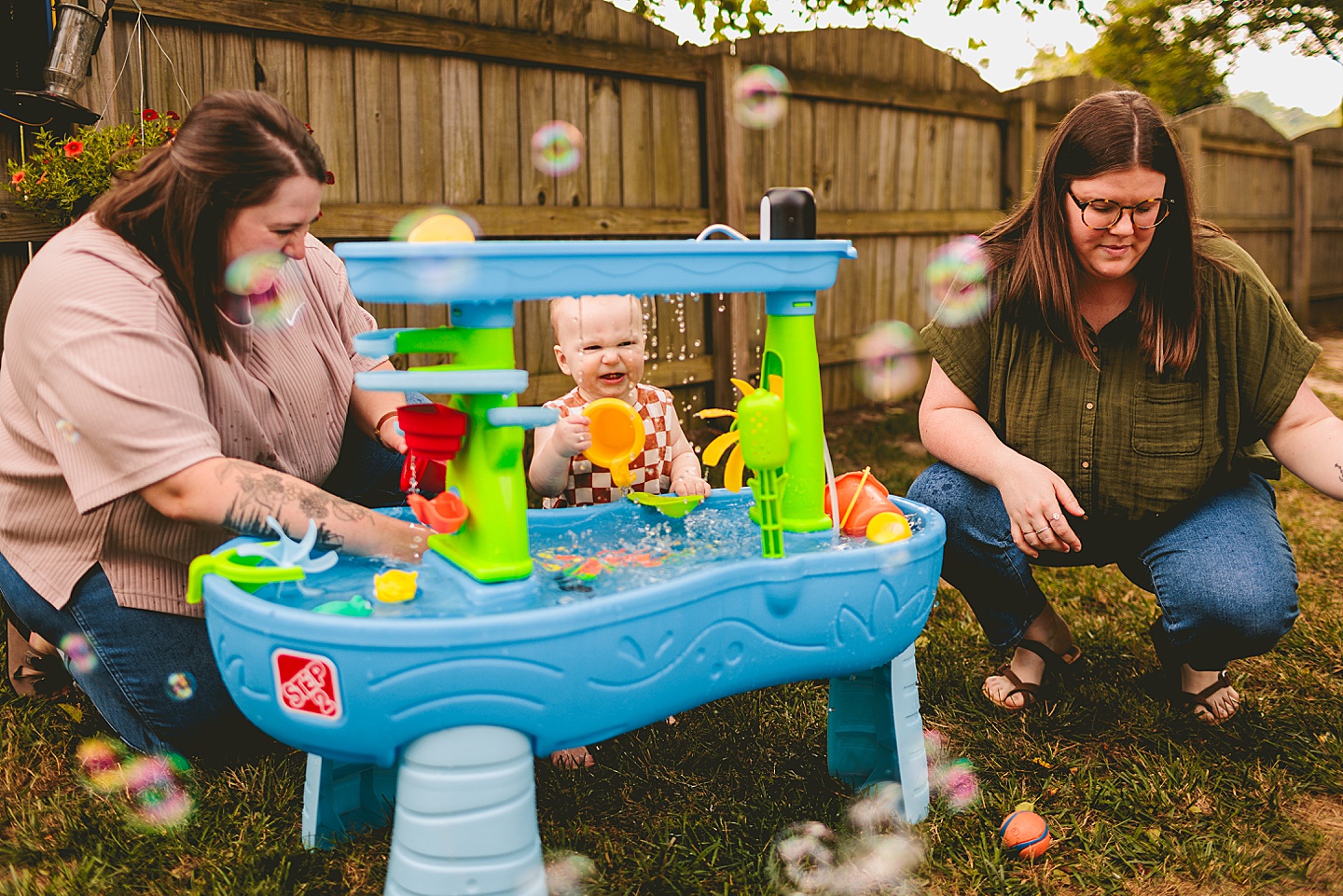One year old baby plays at water table outside in NC